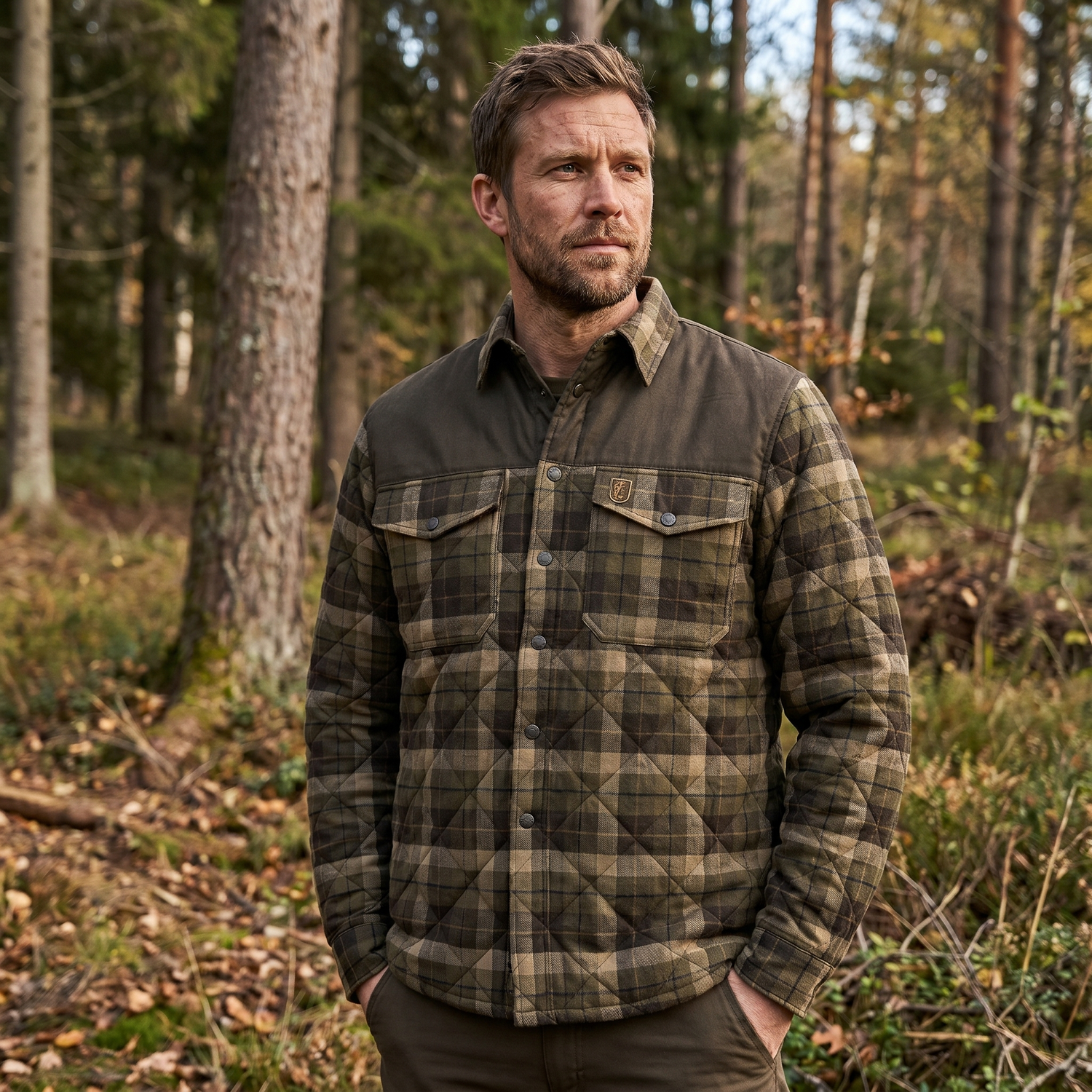 Man wearing a plaid jacket standing in a forest