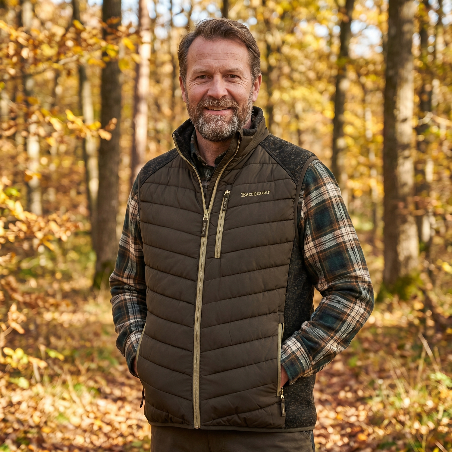 Man wearing a quilted vest and plaid shirt in a forest setting