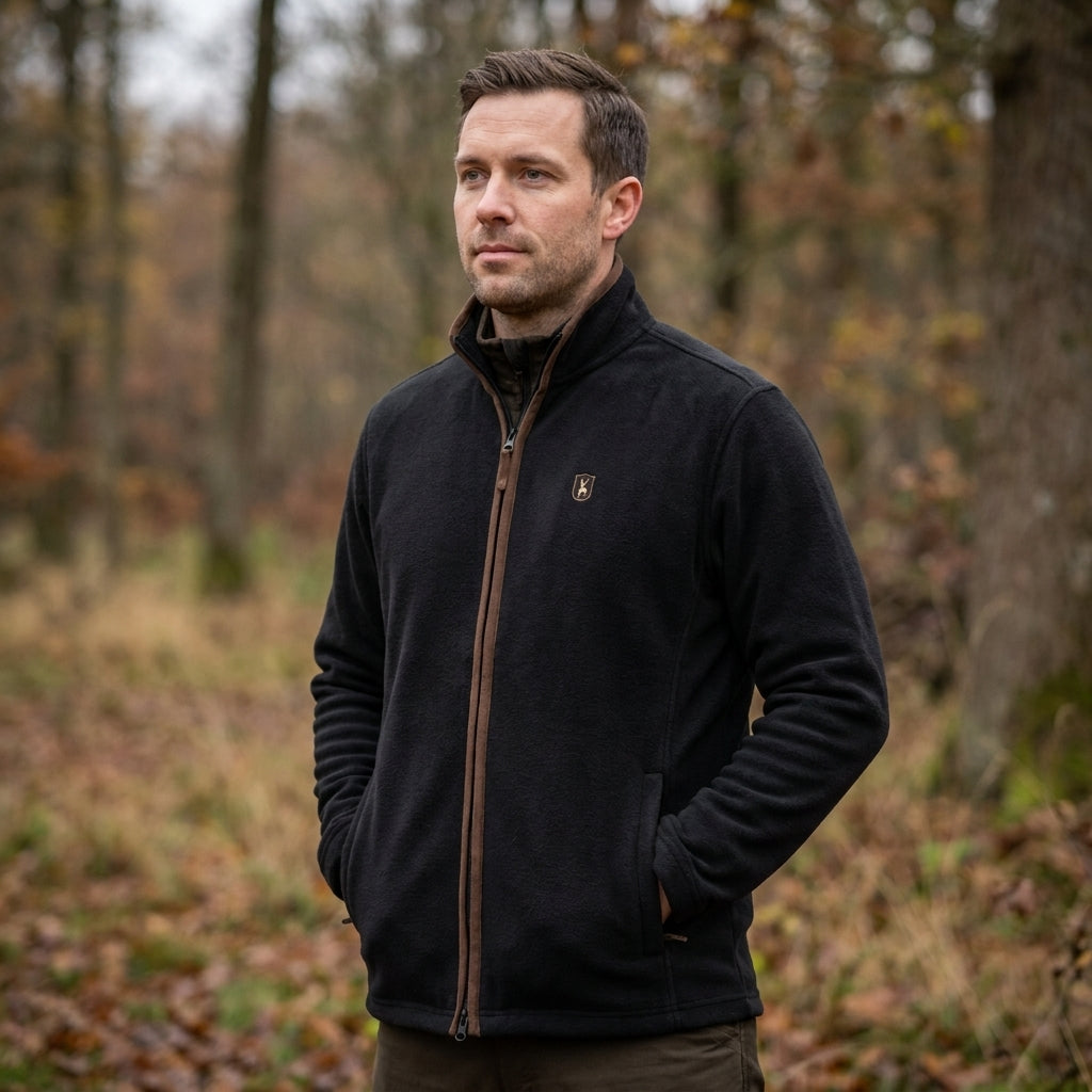 Man wearing a black jacket standing in a forest